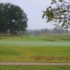 A view of a green with narrow path in foreground at Concho Springs Golf Course