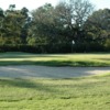 A sunny day view of a hole protected by a bunker at Family Nine from The Golf Club at Houston Oaks.