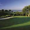 A sunny day view of a hole with water in the distance at White Bluff Golf Club.