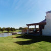 A sunny day view of the clubhouse and a fairway at Whiskey Ranch.