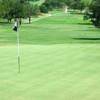 A view of green with narrow road on the left at San Antonio Country Club