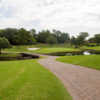 A view of a green surrounded by bunkers at Brook Hollow Golf Club.